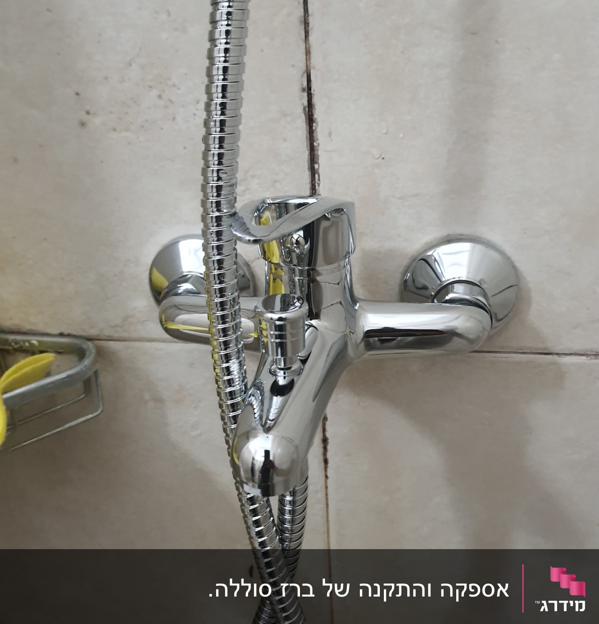 ברז כרום עם צינור מקלחת על קיר אריחים